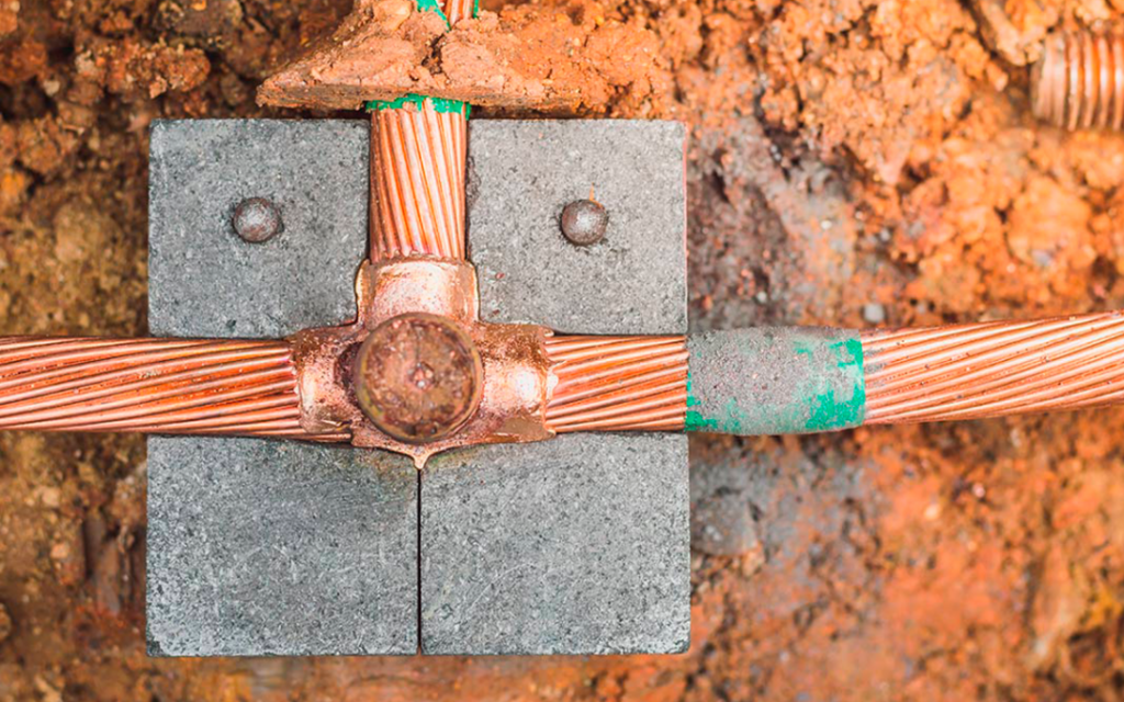 Conectores de cobre de un sistema de puesta a tierra en un registro de concreto
