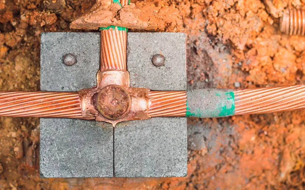 Conectores de cobre de un sistema de puesta a tierra en un registro de concreto